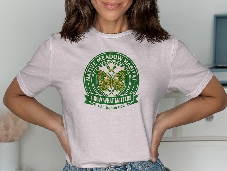 White t-shirt with a circular Native Meadow Habitat logo featuring butterflies and text.