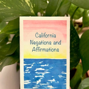 May include: A watercolor painting of a sunset over the ocean with the text "California Negations and Affirmations" in blue.