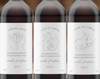 Puede incluir: Tres botellas de vino con etiquetas blancas que presentan ilustraciones de línea negra de un bebé, el texto CUVÉE DE L'AMOUR y el año 2027. Las etiquetas incluyen frases en francés, los nombres amélie et antoine, 750ml y 13% vol.