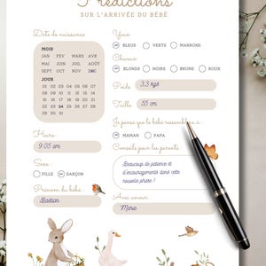 May include: A decorative baby arrival prediction chart with watercolor illustrations of animals and flowers. The chart includes sections for birth date, time, weight (3.3 kgs), and height (55 cm). A black pen rests on the chart.