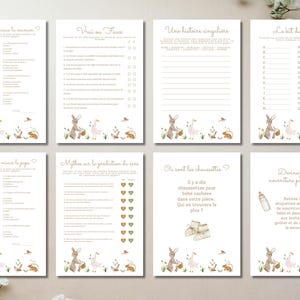 May include: A set of eight cream-colored baby shower game cards. Each card features a different game with text in French, along with illustrations of bunnies, baskets, and flowers. The cards are arranged on a white surface.