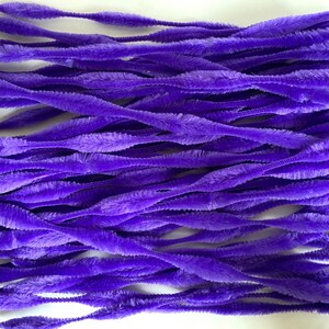 May include: A bunch of purple pipe cleaners, also known as chenille stems, are arranged in a pile. The pipe cleaners are soft and fuzzy, and they are perfect for crafting.