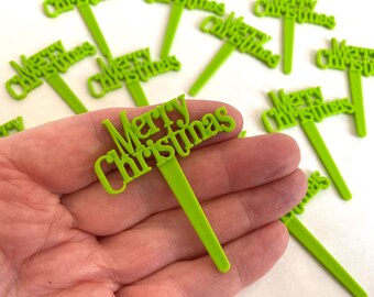 May include: Green plastic cake toppers with the words "Merry Christmas" on them.