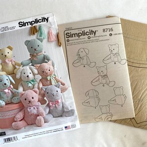 May include: A Simplicity sewing pattern for making stuffed animals. The pattern includes instructions for making a variety of animals, including a cat, a dog, and a bear. The pattern is printed on white paper with black ink. The pattern number is 8716.