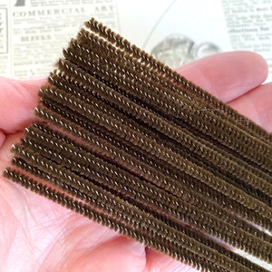 May include: A bundle of brown pipe cleaners. The pipe cleaners are made of a soft, fuzzy material and are perfect for crafting.