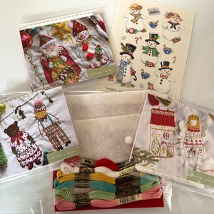 May include: A set of embroidery kits featuring various winter holiday themes. The kits include colorful embroidery floss, fabric, and patterns for stitching a snowman, a house, a bear, and a Santa Claus.