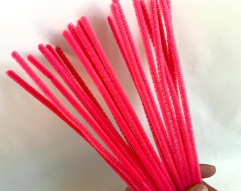 May include: A bundle of bright pink pipe cleaners. The pipe cleaners are long and thin, and they are all bundled together.