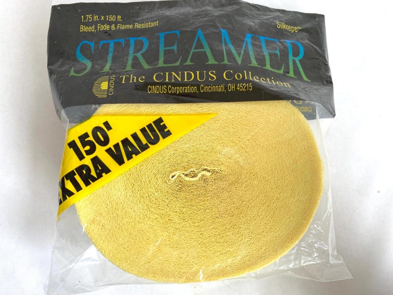 May include: A roll of yellow streamer in a clear plastic package. The package has text that reads "STREAMER" and "150' EXTRA VALUE". The streamer is 1.75 inches by 150 feet and is bleed, fade, and flame resistant.