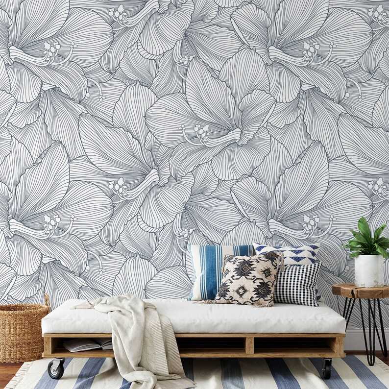Peut inclure: Un canap&eacute; blanc avec une couverture blanche et des coussins &agrave; motifs bleus et blancs est plac&eacute; devant un mur avec un motif floral bleu et blanc.