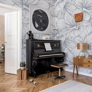 Peut inclure: Un piano &agrave; queue noir sur fond de papier peint floral. Le papier peint pr&eacute;sente un motif floral blanc et gris. Le piano a un clavier noir et blanc et un banc de piano noir. Il y a une petite plante sur un support en bois &agrave; c&ocirc;t&eacute; du piano.