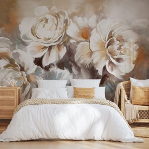 May include: A white bed with a white duvet cover and a tan knitted throw blanket. The bed is in front of a wall with a large abstract floral mural in shades of brown, white, and beige.