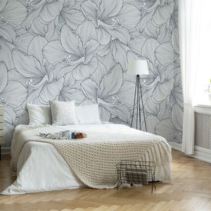 Peut inclure: Un lit blanc avec une couverture blanche et un coussin blanc dans une chambre avec un mur blanc orn&eacute; d'un papier peint floral noir et blanc.