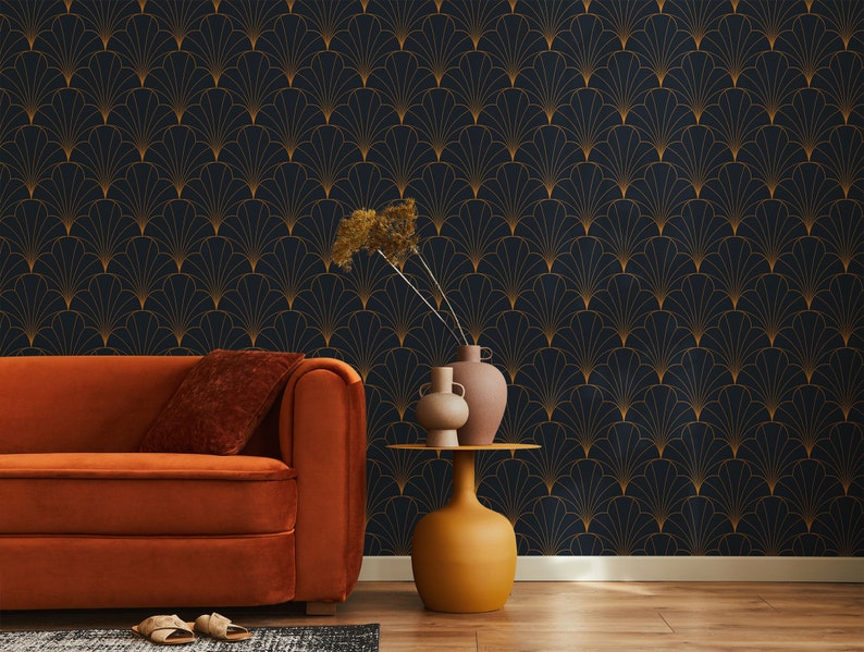 K&ouml;nnte beinhalten: Ein Wohnzimmer mit einem orangefarbenen Sofa und einem Beistelltisch mit zwei Vasen und getrockneten Blumen. Die Wand ist mit dunkelblauem Tapetenpapier mit einem goldenen geometrischen Muster bedeckt.