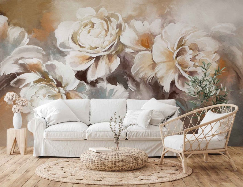 May include: A white couch and a wicker chair in a living room with a large floral wall mural featuring white and brown flowers.