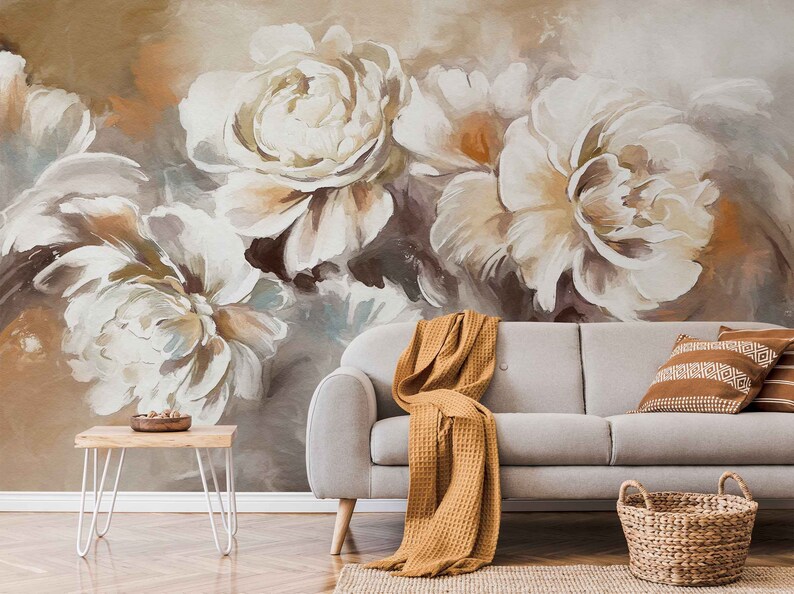 May include: A living room interior design featuring a white couch with a brown throw blanket, a woven basket, and a wooden side table. The wall is decorated with a large abstract painting of white and brown flowers.