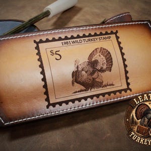 May include: A white ceramic mug with a black handle and the text "But First, Coffee" in a bold, black font. The mug is set against a blurred background, suggesting a cozy setting.