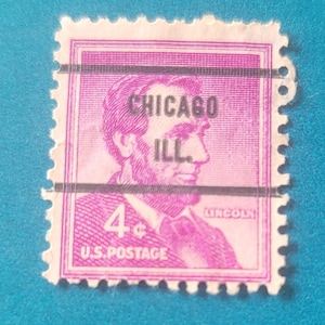 Może przedstawiać: Stary amerykański znaczek pocztowy o nominale 4 centów przedstawiający portret Abrahama Lincolna z tekstem "CHICAGO ILL." i "LINCOLN" nadrukowanym na fioletowo.