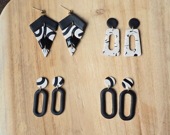 May include: A set of six black and white geometric earrings. The earrings are made of polymer clay and have a modern, abstract design.