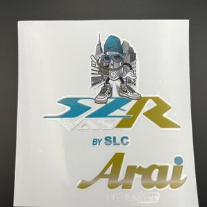 Op de afbeelding: Een Arai-helm sticker met een cartoonfiguur dat een blauwe hoed en zonnebril draagt, staand voor een skyline van een stad. De sticker zegt "SZR by SLC" en "Arai Helmet".