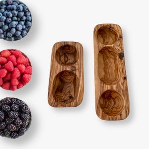 Peut inclure: Deux plats de service en bois avec trois bols séparés. Les plats sont en bois d'olivier et présentent un motif de grain de bois naturel.