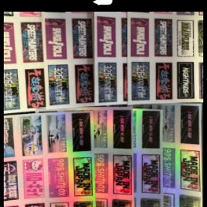 Könnte beinhalten: Eine Sammlung von 1:10 Drift Slaps Aufklebern mit verschiedenen Designs und Texten, darunter "SAVAGE SCALE", "NIGHTKIDS", "SPEETHUNTERS", "MADE IN JAPAN" und "90'S SHITBOX". Die Aufkleber sind rechteckig und haben einen holografischen Effekt.