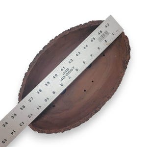 May include: A brown, oval-shaped terracotta planter with a rough, bark-like texture. The planter has drainage holes and measures approximately 47 inches in length.