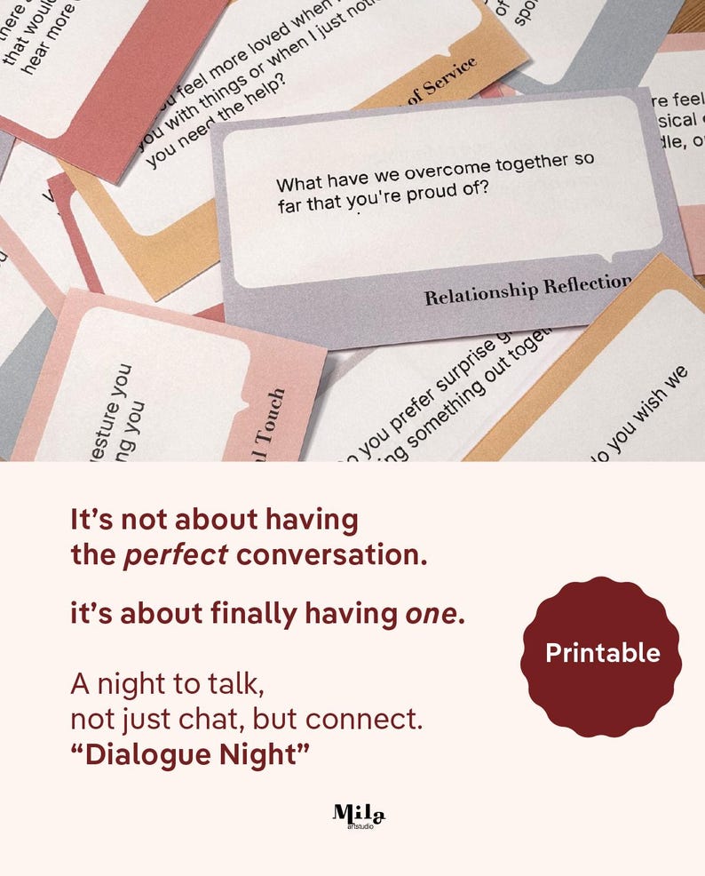 May include: A collection of rectangular cards with rounded corners in shades of pink, gray, and tan, featuring printed questions like What have we overcome together so far that you're proud of? and the text Dialogue Night with a red seal.