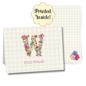 Puede incluir: Un juego de papelería personalizada con un diseño floral de la letra "W". Las tarjetas presentan un patrón de cuadros vichy amarillo claro y el nombre "Erica Wiwode" impreso en un tono rojo suave. Un pequeño ramo de flores está en la esquina inferior derecha.