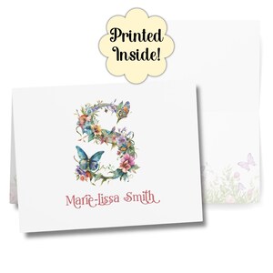 Puede incluir: Juego de papelería blanco con un diseño floral de la letra "S", mariposas y el nombre "Marie-lissa Smith". El texto "Printed Inside!" es visible. El juego incluye una tarjeta y un sobre.
