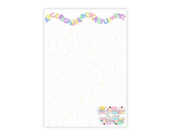 Può includere: Un blocco note bianco con uno striscione arcobaleno pastello con l'alfabeto nella parte superiore. Il blocco note ha un design a matita sparso e un logo decorativo con la scritta "Mrs. Clark" in basso.