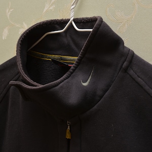 May include: A dark gray zip-up jacket with a silver Nike swoosh logo on the chest.