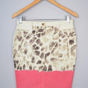 Puede incluir: Una falda vaquera de estampado animal blanco y marrón con un efecto degradado rosa en la parte inferior.