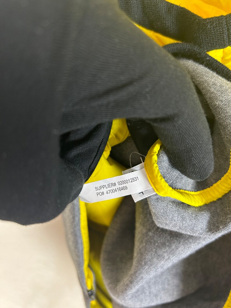 Puede incluir: Primer plano de una etiqueta amarilla con texto negro que dice "SUPPLIER# 0200012831 PO# 4700416469".