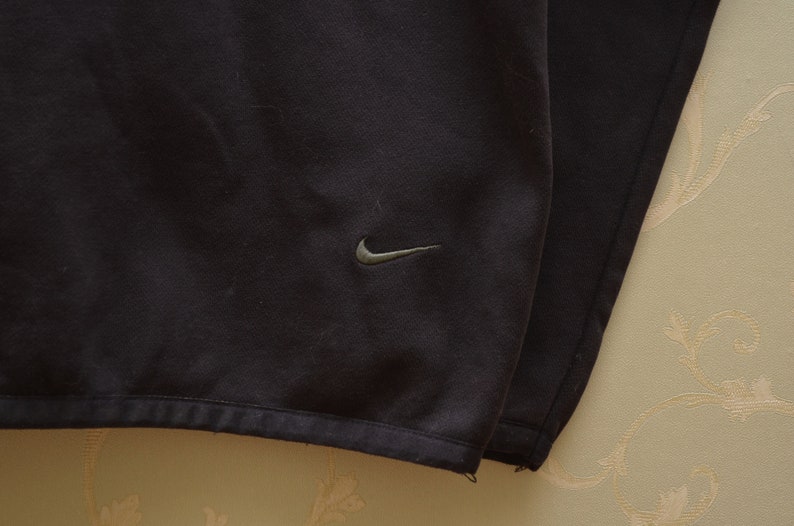 May include: Black Nike sweatshirt with a small Nike logo on the front.
