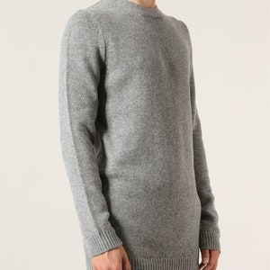 May include: A gray long-sleeved sweater with a crew neck.