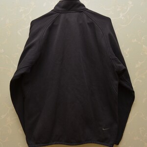 May include: A black fleece jacket with a zipper closure and a small Nike logo on the lower right side.