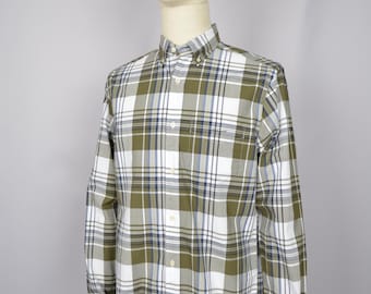 Puede incluir: Una camisa de manga larga con botones y un estampado de cuadros blancos, verdes y azules.