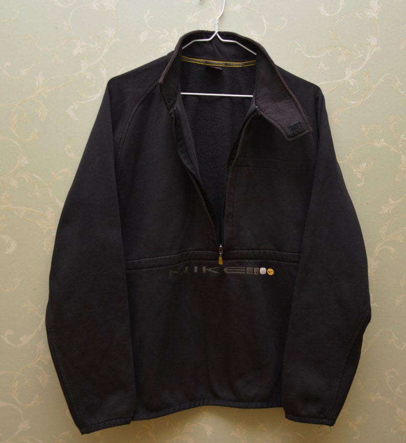 May include: A black Nike fleece jacket with a half-zip closure and a small Nike logo on the front.
