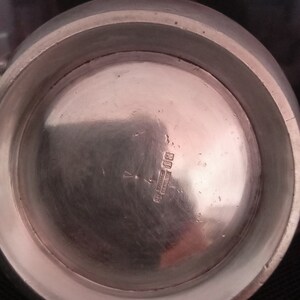 May include: The underside of a silver pitcher with the inscription "Sterling Silver, England" and the number "801" visible.