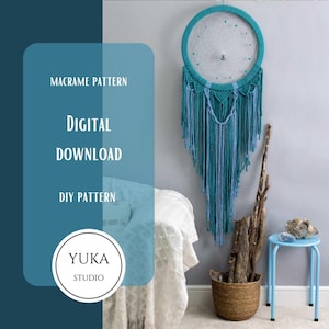 May include: Digital download pattern for a teal and blue macrame dreamcatcher. The pattern is for a DIY project and is available for purchase. The image shows the finished dreamcatcher hanging on a wall.