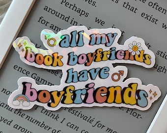 May include: A colorful sticker with the text "all my book boyfriends have boyfriends" in a rainbow font. The sticker is on a gray background.