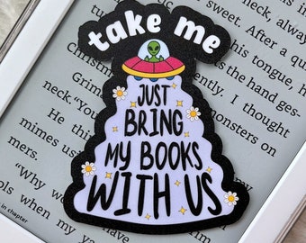 Puede incluir: Una pegatina negra y morada con un extraterrestre de dibujos animados en un platillo volante. La pegatina dice "Take me Just Bring My Books With Us".