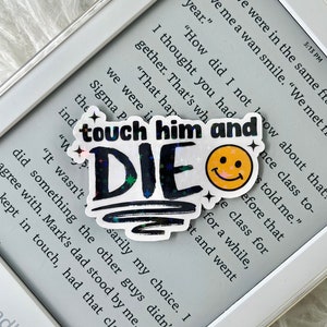 May include: A holographic sticker with the text "touch him and DIE" in black and white with a yellow smiley face. The sticker has a glittery, iridescent finish.