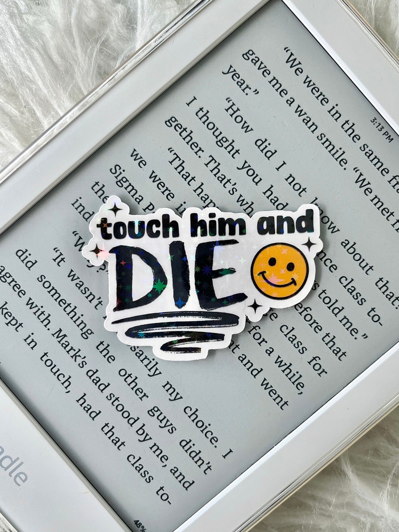 May include: A holographic sticker with the text "touch him and DIE" in black and white with a yellow smiley face. The sticker has a glittery, iridescent finish.