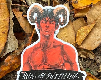 Op de afbeelding: Een gestanste sticker met een roodkleurige figuur met grote, gekrulde ramshoorns en puntige oren. De figuur heeft donker, krullend haar en een gespierde borstkas. Onder de figuur staat in een zwarte penseelstreek de witte tekst: RUN, MY SWEETLING.