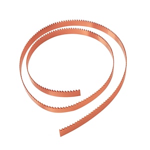 May include: Coiled copper-colored band saw blades with sharp, jagged teeth. The blades are arranged in a spiral, showcasing their flexibility and design. The blades are designed for cutting wood, metal, or other materials.