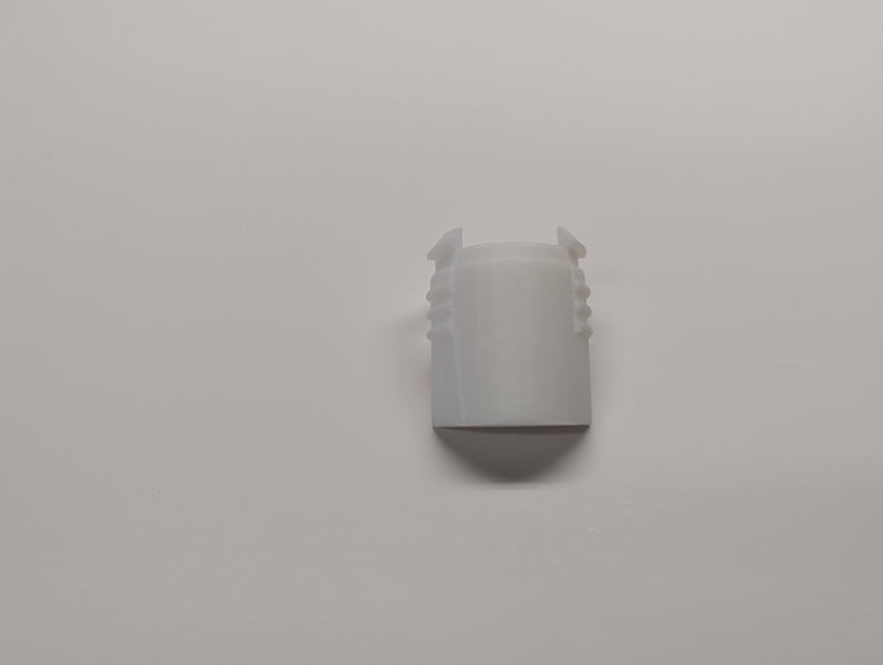 Pu&ograve; includere: Tappo per bottiglia in plastica bianca con corpo cilindrico e base conica. Il tappo ha una serie di scanalature verticali attorno al corpo e due piccole linguette nella parte superiore. L'oggetto &egrave; posto su uno sfondo bianco. Altezza di circa 4 cm.