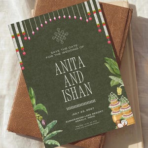 May include: A dark olive green wedding save the date card featuring white text reading ANITA AND ISHAN, JULY 23, 2027, KUMARAKOM LAKE RESORT, KERALA, INDIA. The design includes hanging floral garlands, green tropical leaves, and a coconut illustration.
