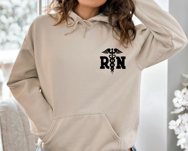 May include: A beige hoodie with a black  "RN" graphic and a caduceus symbol.