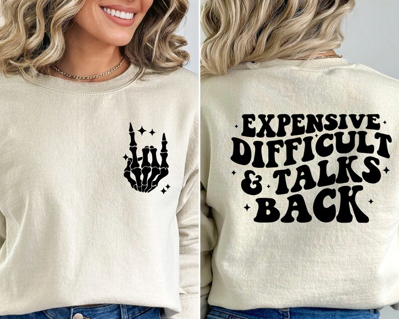 K&ouml;nnte beinhalten: Ein cremefarbener Pullover mit einer schwarzen Skeletthand, die ein Rock'n'Roll-Zeichen auf der Vorderseite macht, und dem Text "EXPENSIVE DIFFICULT & TALKS BACK" auf der R&uuml;ckseite.